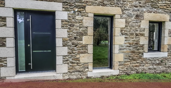 Porte d’entrée aluminium sur une maison en pierre