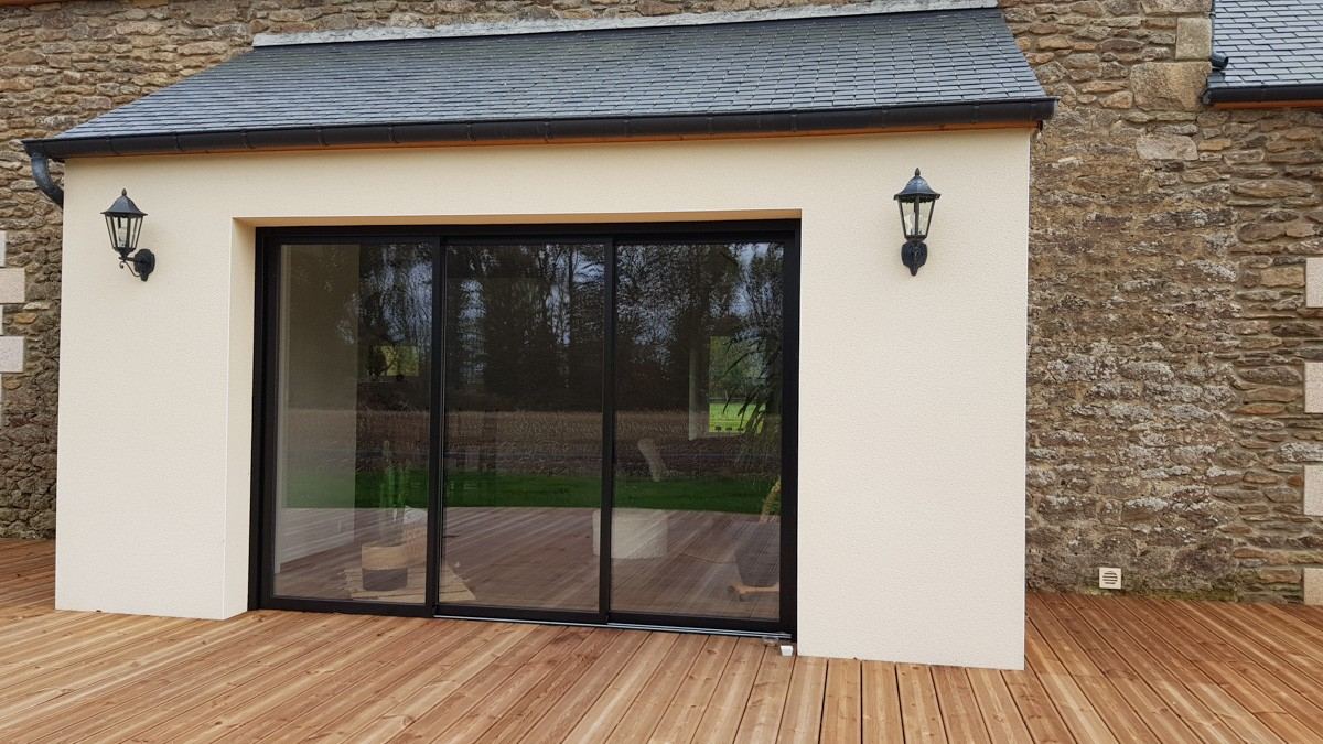 Baie vitrée coulissante sur une extension avec terrasse en bois