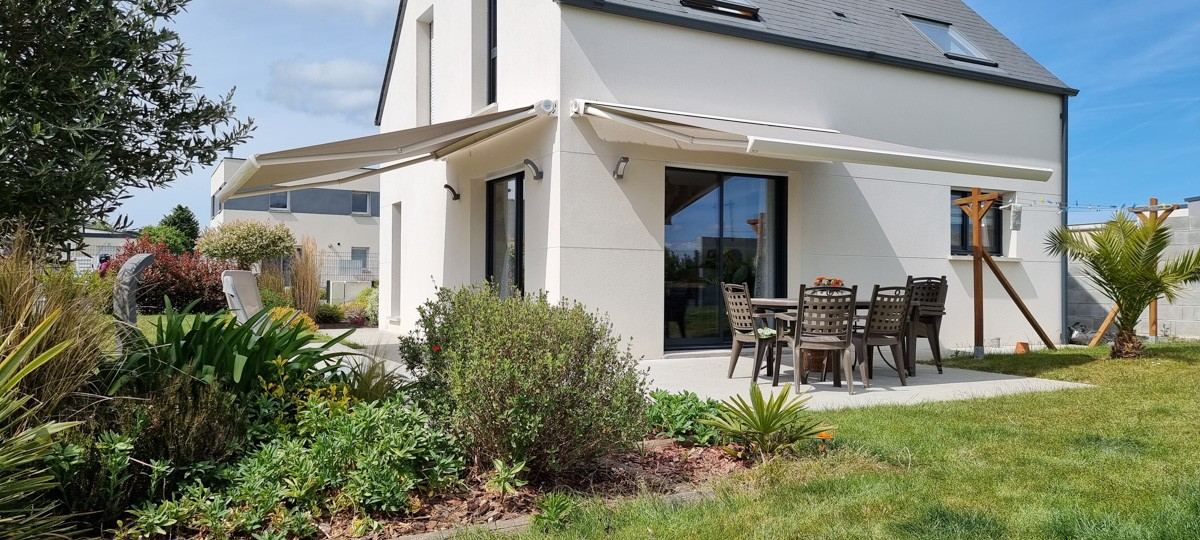 Store banne sur une maison au jardin fleuri